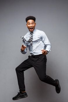 Business Concept - Full length portrait of successful african american businessman happy jumping in the office