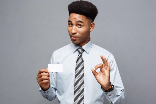 Business Concept - Happy handsome professional african american businessman showing name card to client