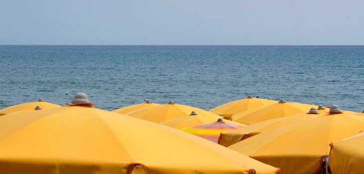 Beach umbrellas with background of the sea during a summer day.