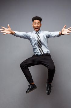 Business Concept - Full length portrait of successful african american businessman happy jumping in the office