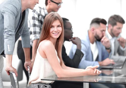 A group of business people listening to a colleague, addressing an office meeting