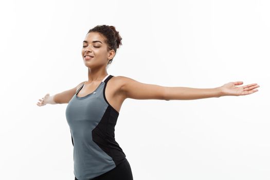 Healthy and Fitness concept - Portrait of young beautiful African American with her hands outstretched and closing eyes feeling relax. Isolated on white studio background