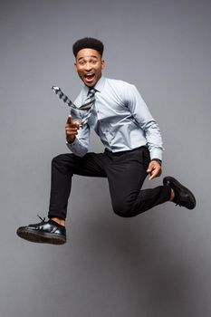 Business Concept - Full length portrait of successful african american businessman happy jumping in the office