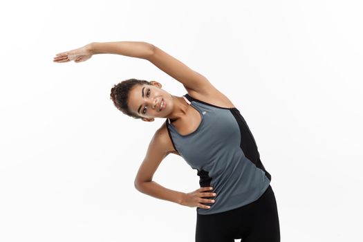 Sport, training, lifestyle and Fitness concept - portrait of beautiful happy African American woman stretching hands. Isolated on white studio background