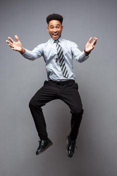 Business Concept - Full length portrait of successful african american businessman happy jumping in the office