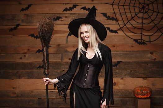 Halloween witch concept - Happy Halloween Sexy Witch holding posing over old wooden studio background