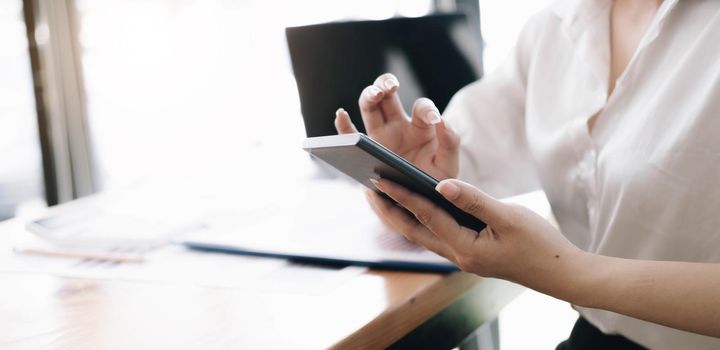 Close up hand of woman using smartphone at office.