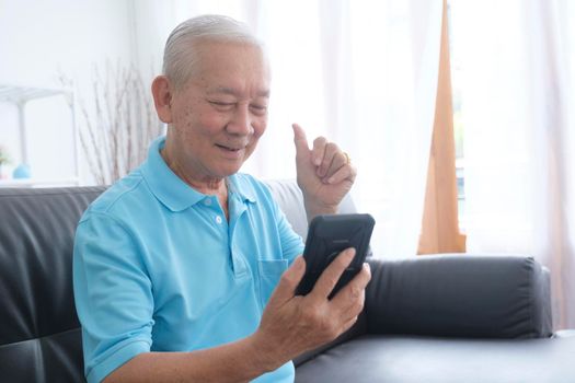 Elderly man making video call and waving at screen, chatting with children, communication with friend distantly, older generation modern tech easy comfortable usage concept..