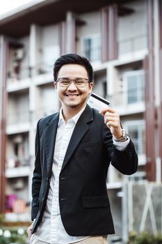 Young Handsome man enjoy shopping online on mobile phone with credit card.