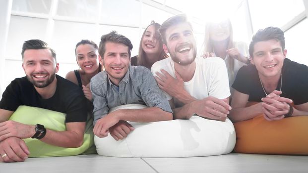 group of young people lying on the floor and smiling. photo with copy space