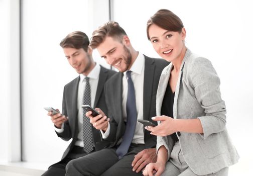 smiling employees using their smartphones.people and technology