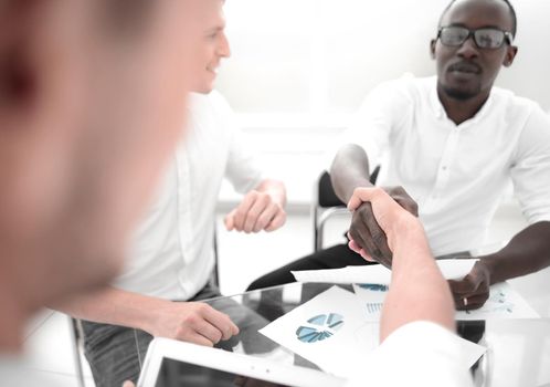 close up.handshake financial partners sitting at the Desk.business concept