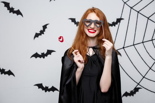 Halloween concept - Beautiful girls in black witch dresses holding party props