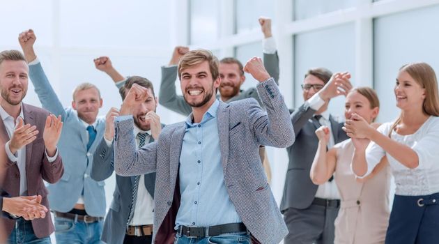 close up. cheerful employees congratulating a colleague on the promotion. success concept