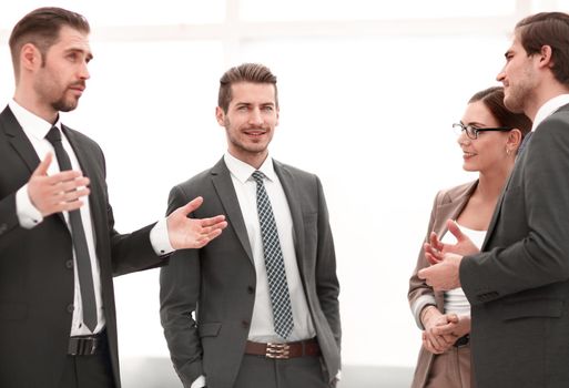 businessman talking to his colleagues standing in the office.the concept of teamwork