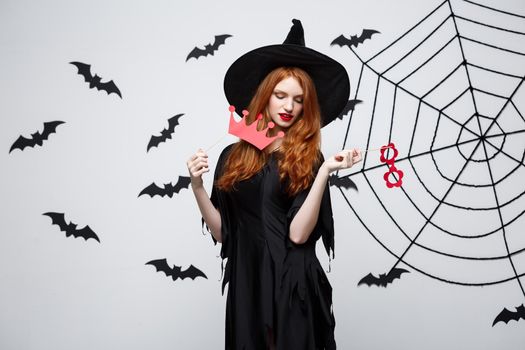 Halloween concept - Beautiful girls in black witch dresses holding party props