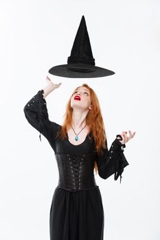Halloween witch concept - Happy Halloween Sexy ginger hair Witch with magic hat flying over her head. Isolated on white background