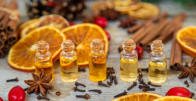 Christmas essential oils in small bottles. Selective focus. Nature.