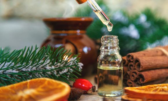 Christmas essential oils in small bottles. Selective focus. Nature.