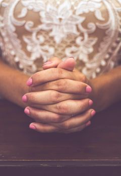 hands of a bride who prays during the wedding ceremony