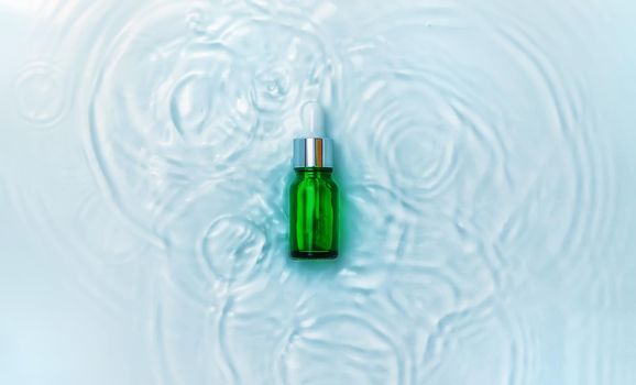 Cosmetics in a bottle in water, skin hydration concept. Hyaluronic acid. Selective focus. Nature.