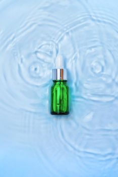 Cosmetics in a bottle in water, skin hydration concept. Hyaluronic acid. Selective focus. Nature.