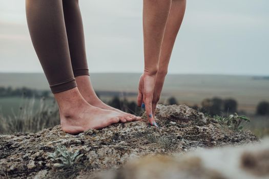 Close Up of Unrecognisable Woman Doing Exercises on the Top of Hill Outdoors