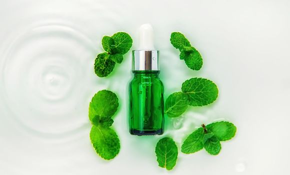 Cosmetics in a bottle in water, skin hydration concept. Selective focus. Nature.
