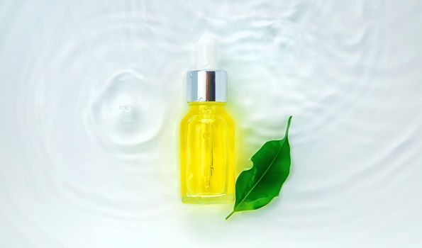 Cosmetics in a bottle in water, skin hydration concept. Selective focus. Nature.