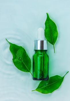 Cosmetics in a bottle in water, skin hydration concept. Selective focus. Nature.