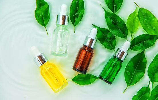 Cosmetics in a bottle in water, skin hydration concept. Selective focus. Nature.