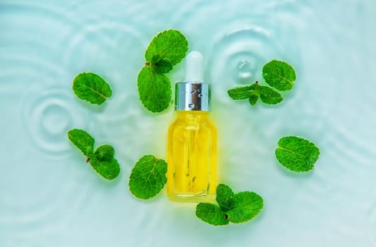 Cosmetics in a bottle in water, skin hydration concept. Selective focus. Nature.