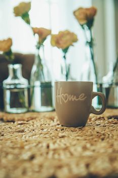 Cup of coffee and flowers on the table at home. Selective focus. Drink.