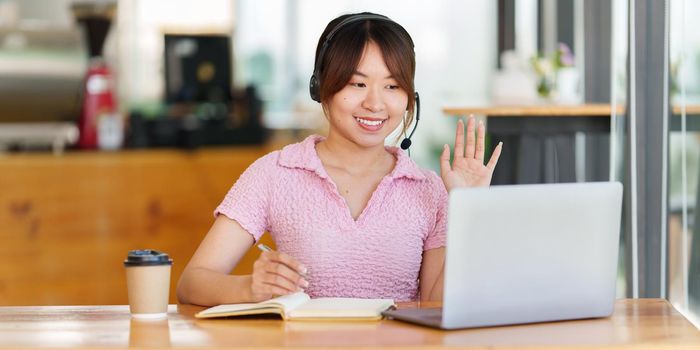 E-learning Online Education concept. Asian woman attentive student student video conference e-learning with teacher on laptop computer at home