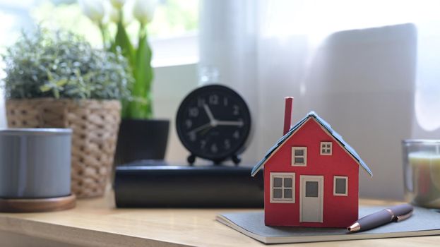 Close up view house model on wooden table. New house, insurance and real estate concept.