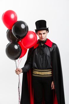 Vampire Halloween Concept - Full-lenght Portrait of handsome caucasian Vampire in black and red halloween costume.