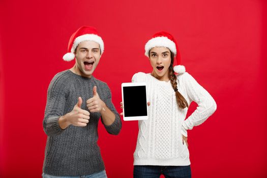 Christmas concept - Happy young couple in sweaters celebrating christmas with playing and dancing.