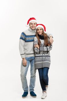 Christmas concept - Full-length Young attractive caucasian couple giving a hug celebrating for Christmas day