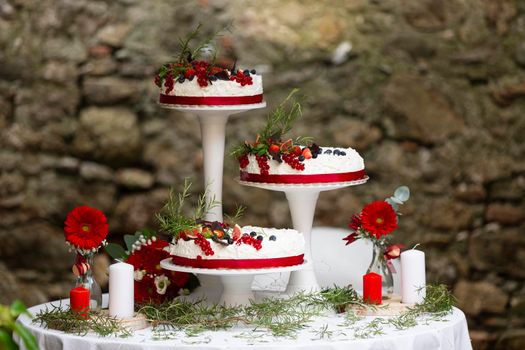 wedding cake decorated with berries, flowers and candles