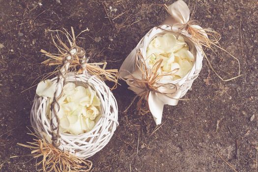 wooden basket with white rose petals, decoration for wedding ceremony