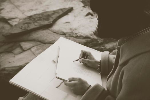 Hands of a girl drawing with pencil