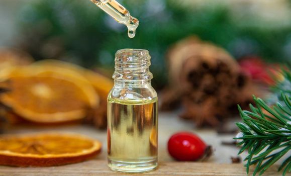 Christmas essential oils in small bottles. Selective focus. Nature.