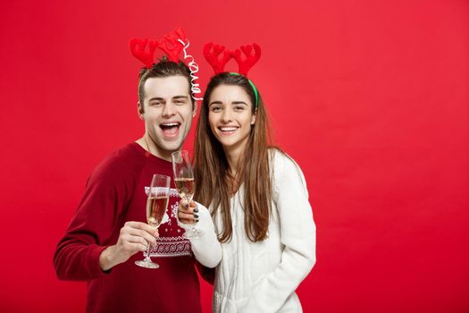 Christmas concept - Happy young couple in sweaters celebrating christmas with Champagne.