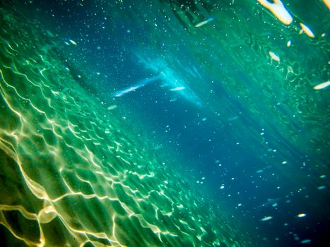 Sea floor with sand and sunlight reflections.