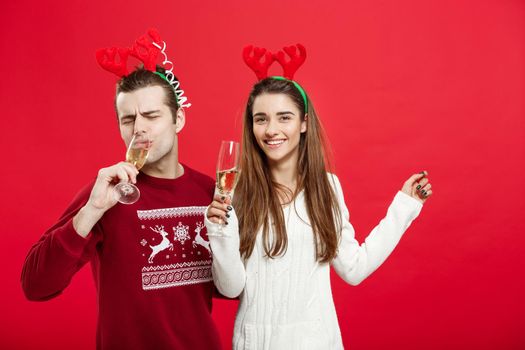 Christmas concept - Happy young couple in sweaters celebrating christmas with Champagne.