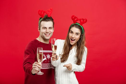 Christmas concept - Happy young couple in sweaters celebrating christmas with Champagne.