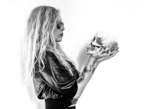 A girl looks death in the face, holds in his hand a skull