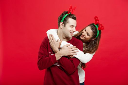 Christmas Concept - Romantic couple in a christmas sweaters huging each other.