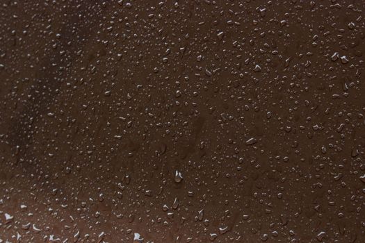 water drops on a brown metal surface, top view, for background. rain drips on the surface.