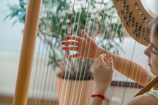 The child plays the harp. Selective focus. Kid.